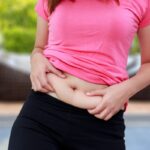 A woman holding herself on her stomach