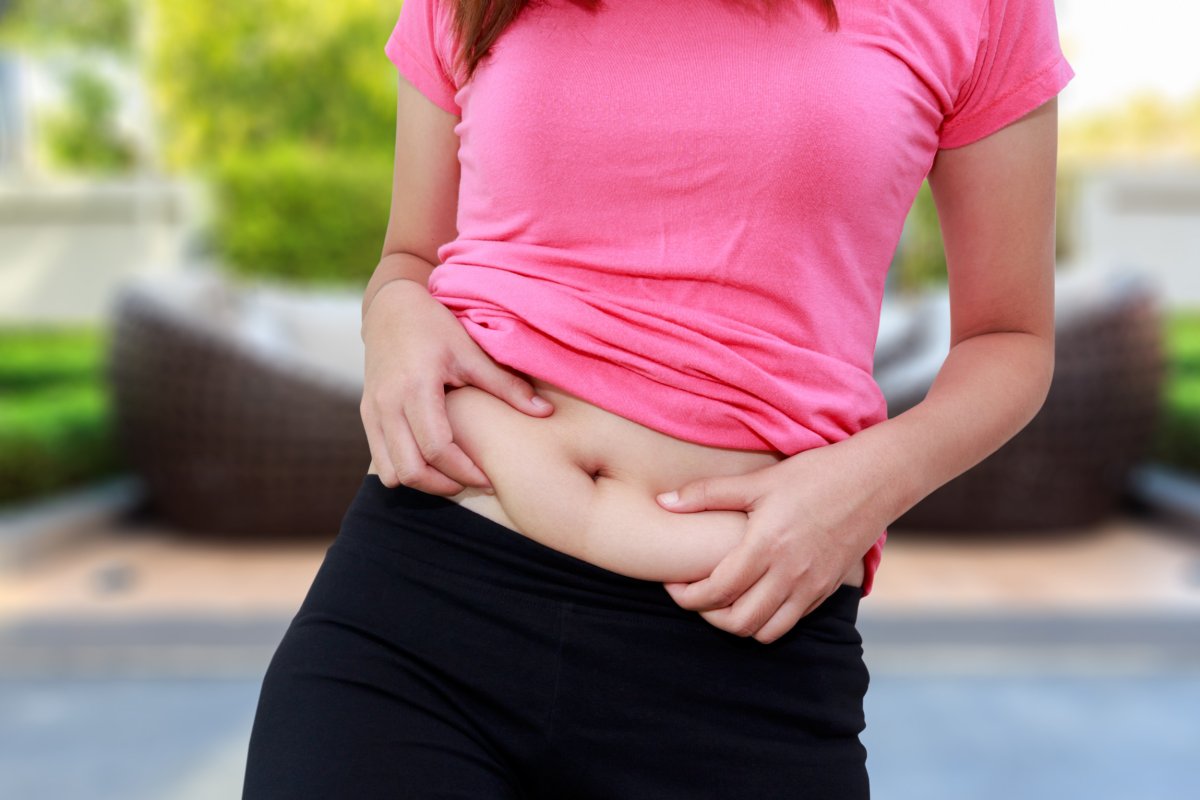 A woman holding herself on her stomach